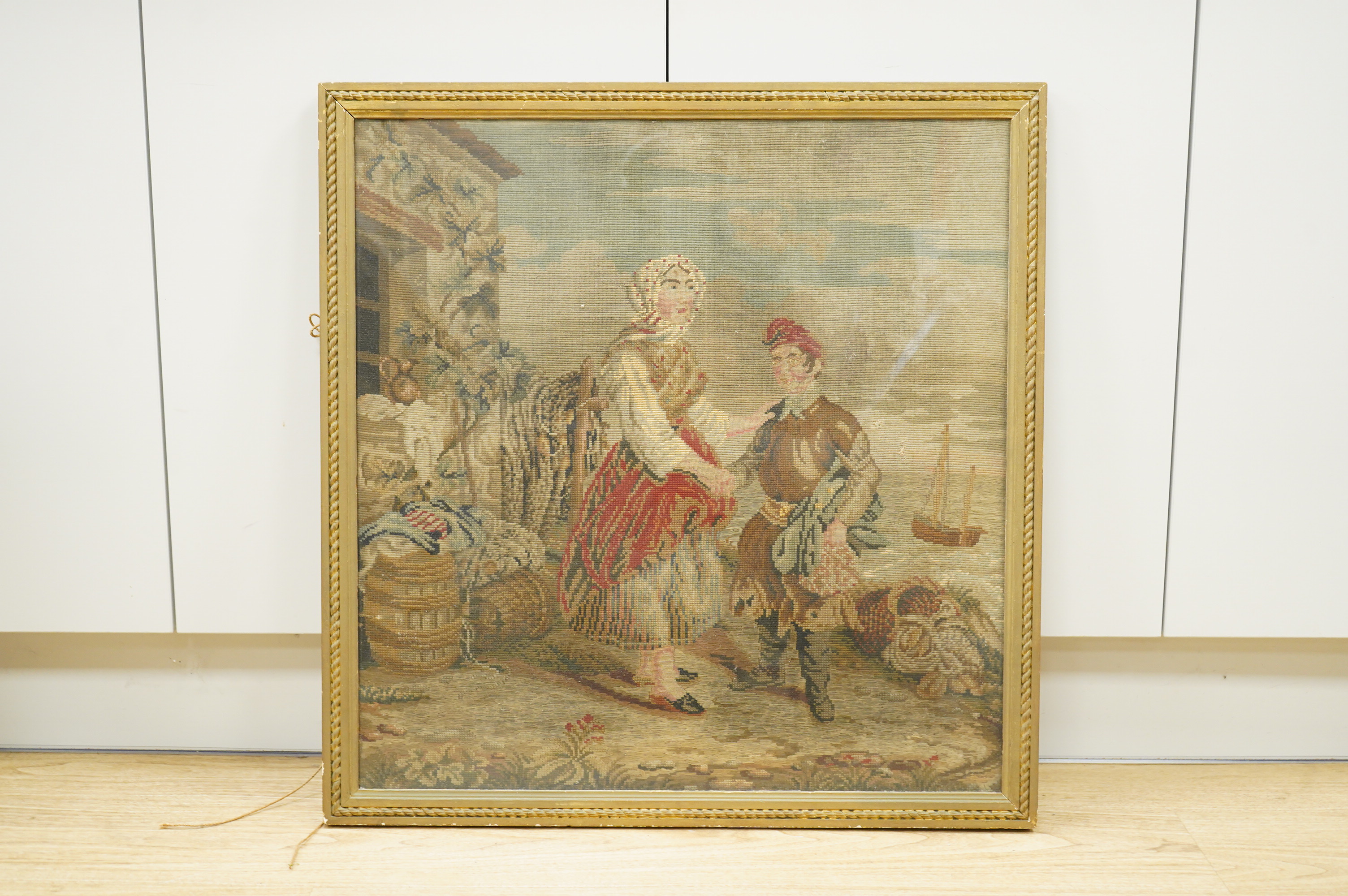 A Victorian woolwork panel, figures before a coastline, framed, 64 x 61cm